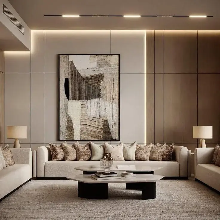 تصميم مجلس سعودي مودرن فاخر يعتمد على تكسيات جدران شيب بورد بألوان رملية ورمادية فاتحة مع إضاءة مخفية وأثاث أنيق.